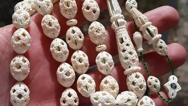Gündüz güvenlik görevlisi, boş zamanlarında tespih ustası! Sanatını dişe işliyor